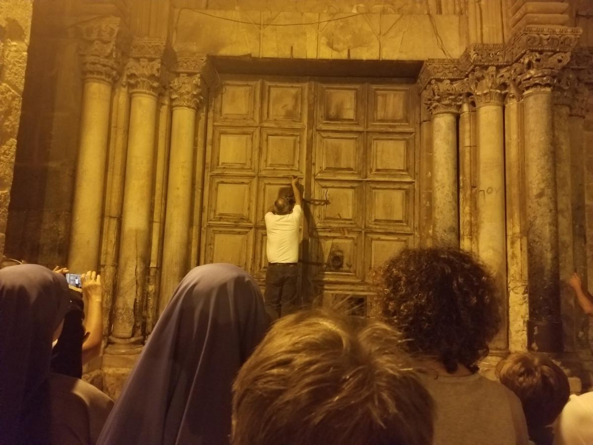 Man locks the door of the church in Jerusalem's old city